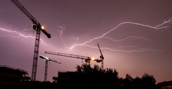 Lightning,Strikes,Behind,The,Cranes,Of,A,Construction,Site,In Lightning,Strikes,Behind,The,Cranes,Of,A,Construction,Site,In